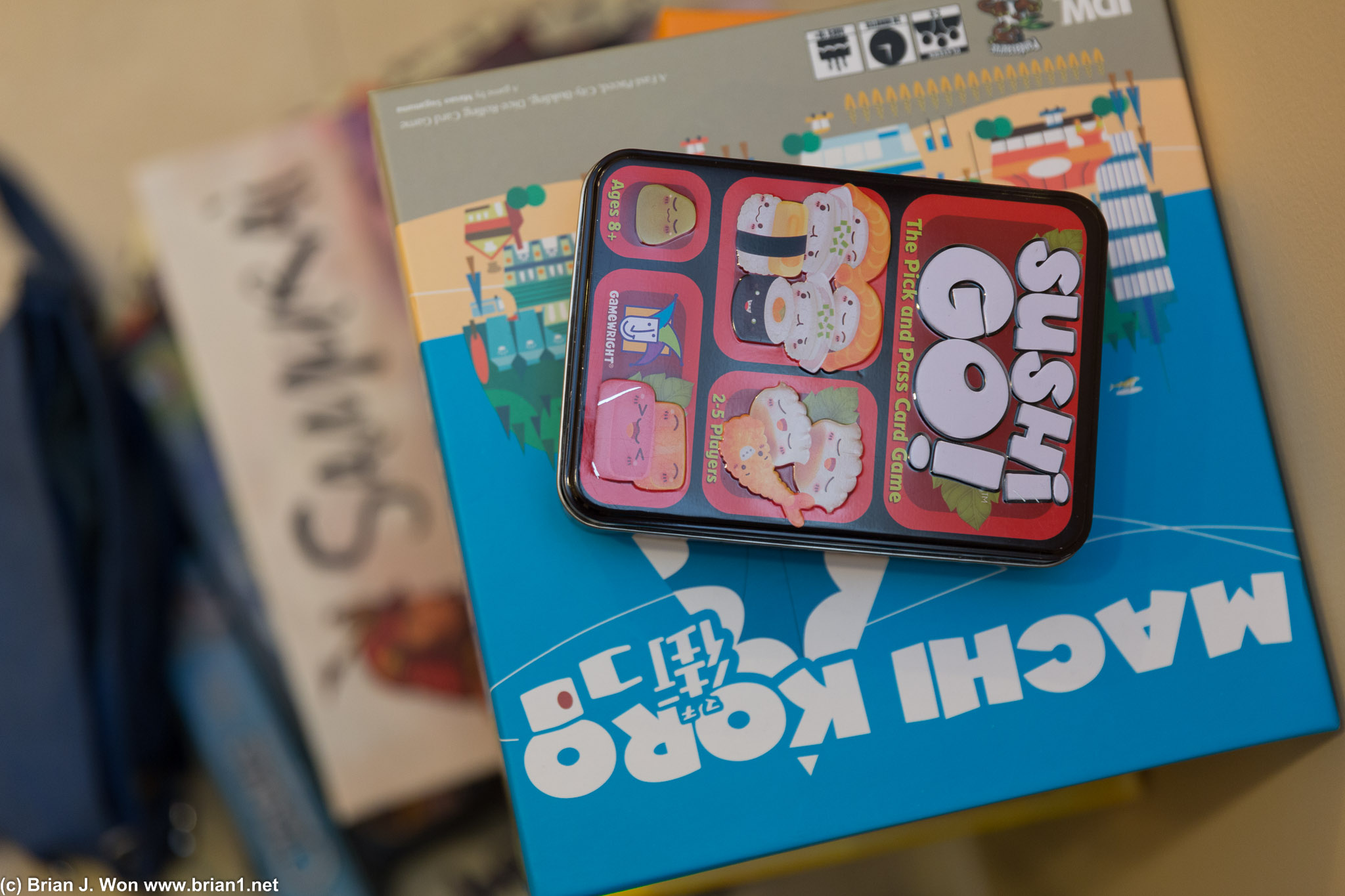 Sushi Go and Machi Koro top the stacks of board games.