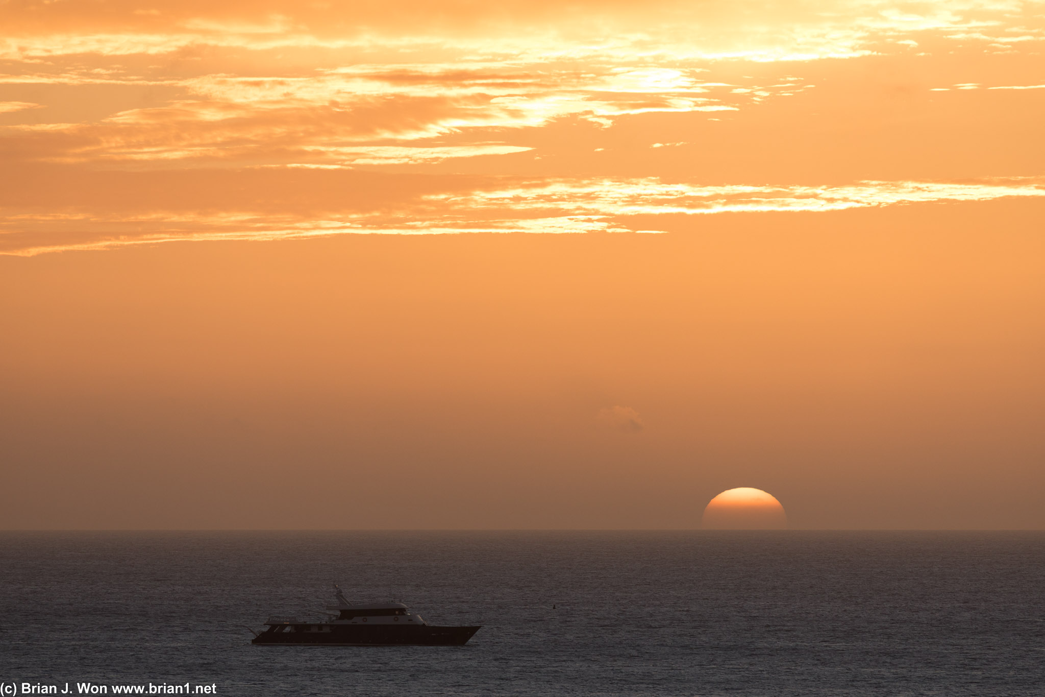 A solitary boat watches the sunset.