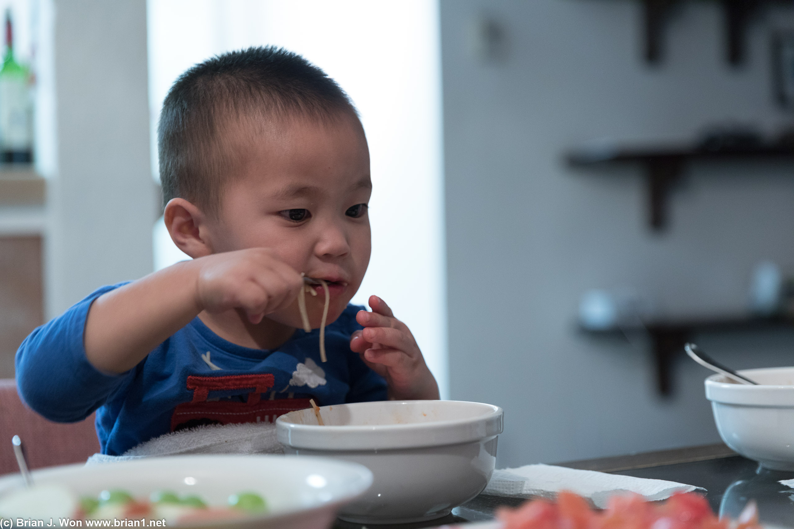 Well-fed kid loves noodles.