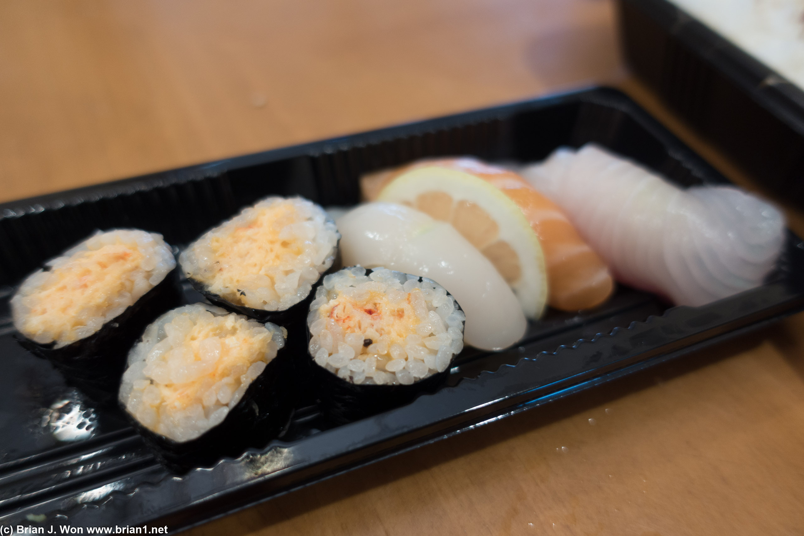 Crab rolls next to scallop, salmon, and yellowtail nigiri.