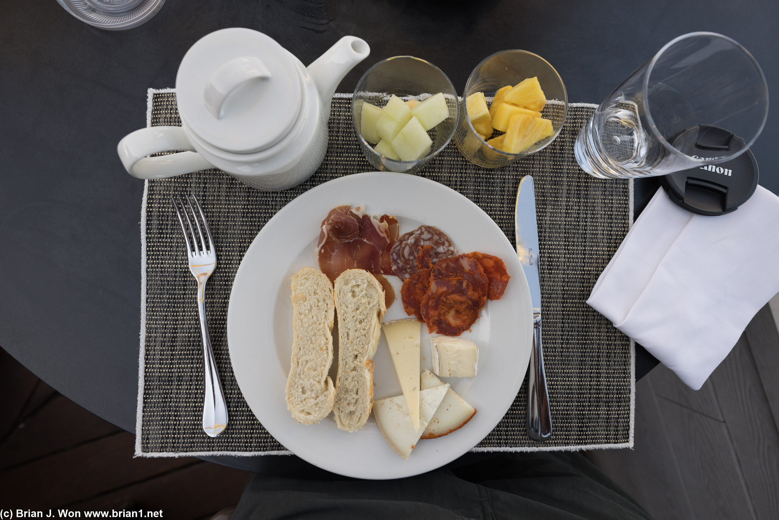 Meat, cheese, bread, fruit, and tea.