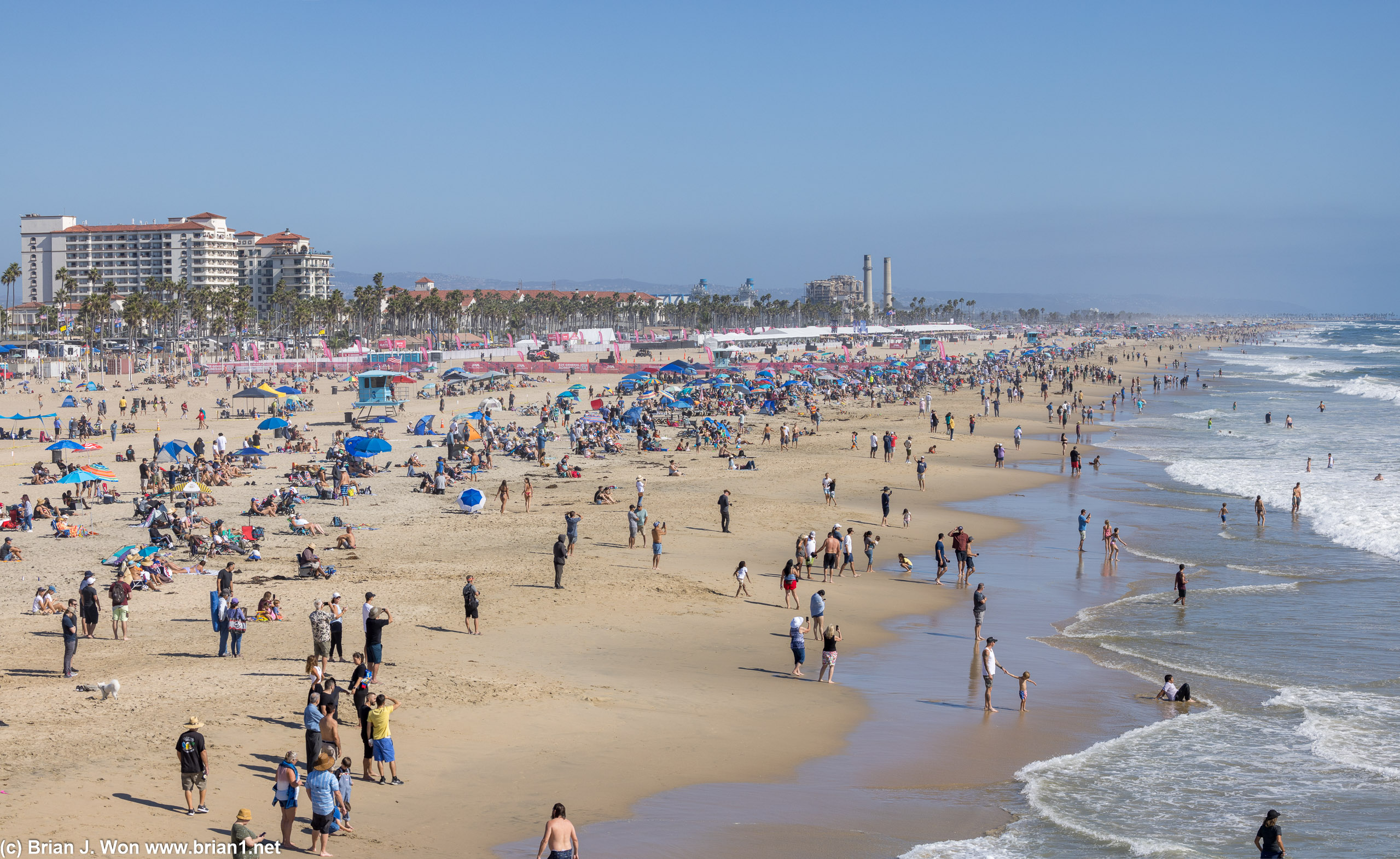 The beach is crowded with both beachgoers and spectators.