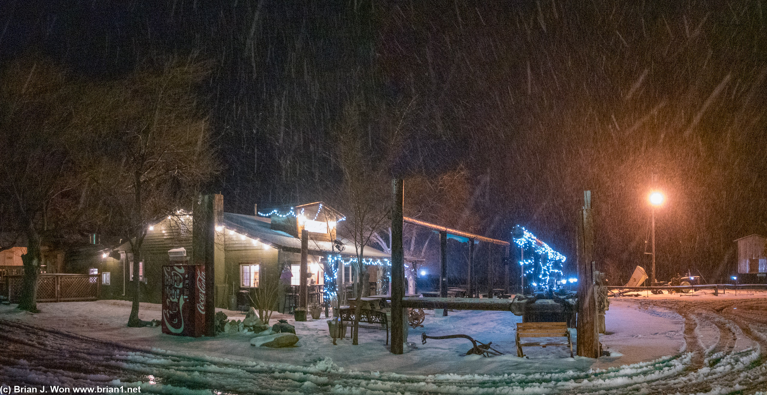 The main building of the RV park and motel bathed in snow and colorful lights.