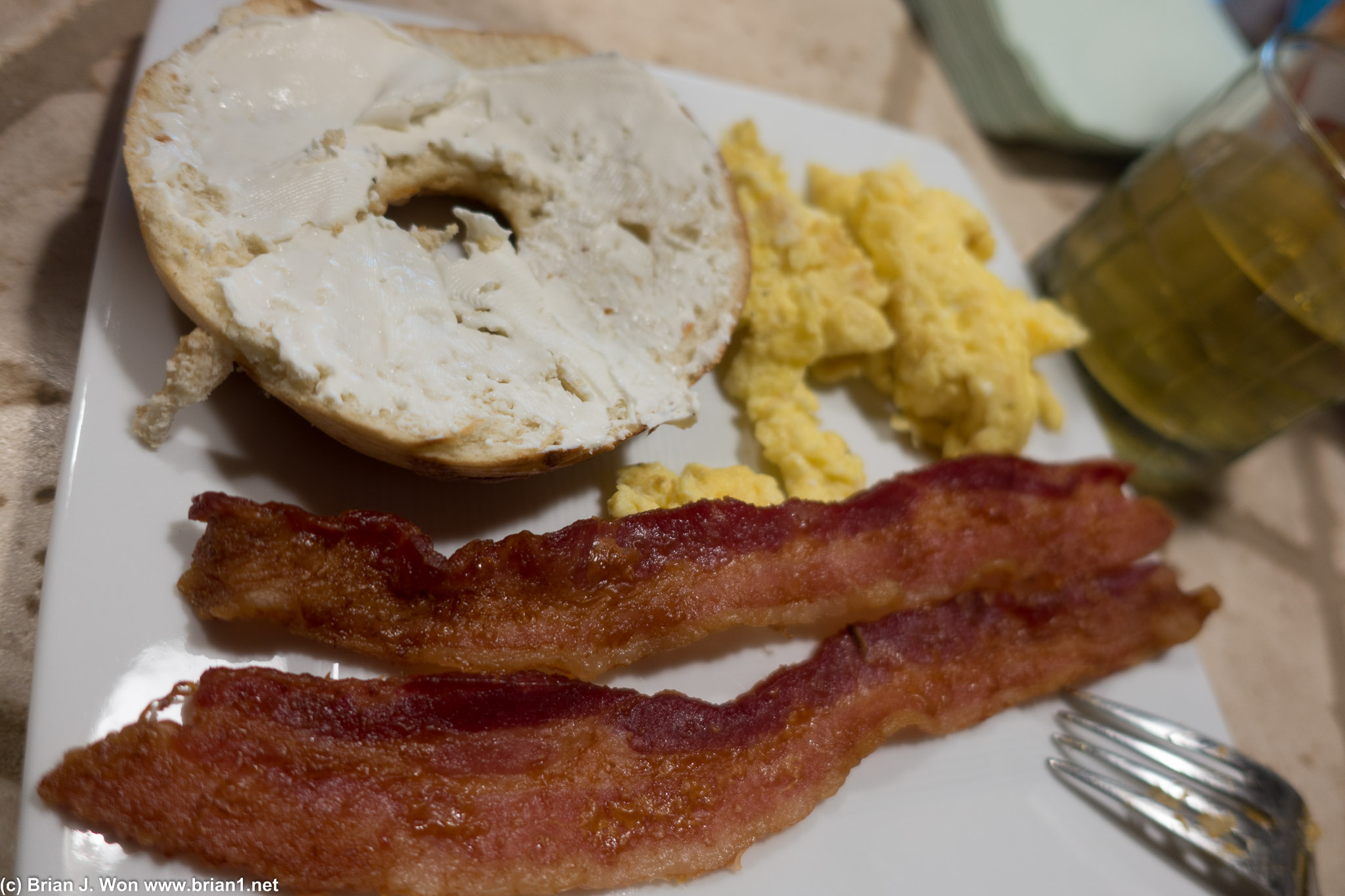 Bagel, scrambled eggs, and bacon.