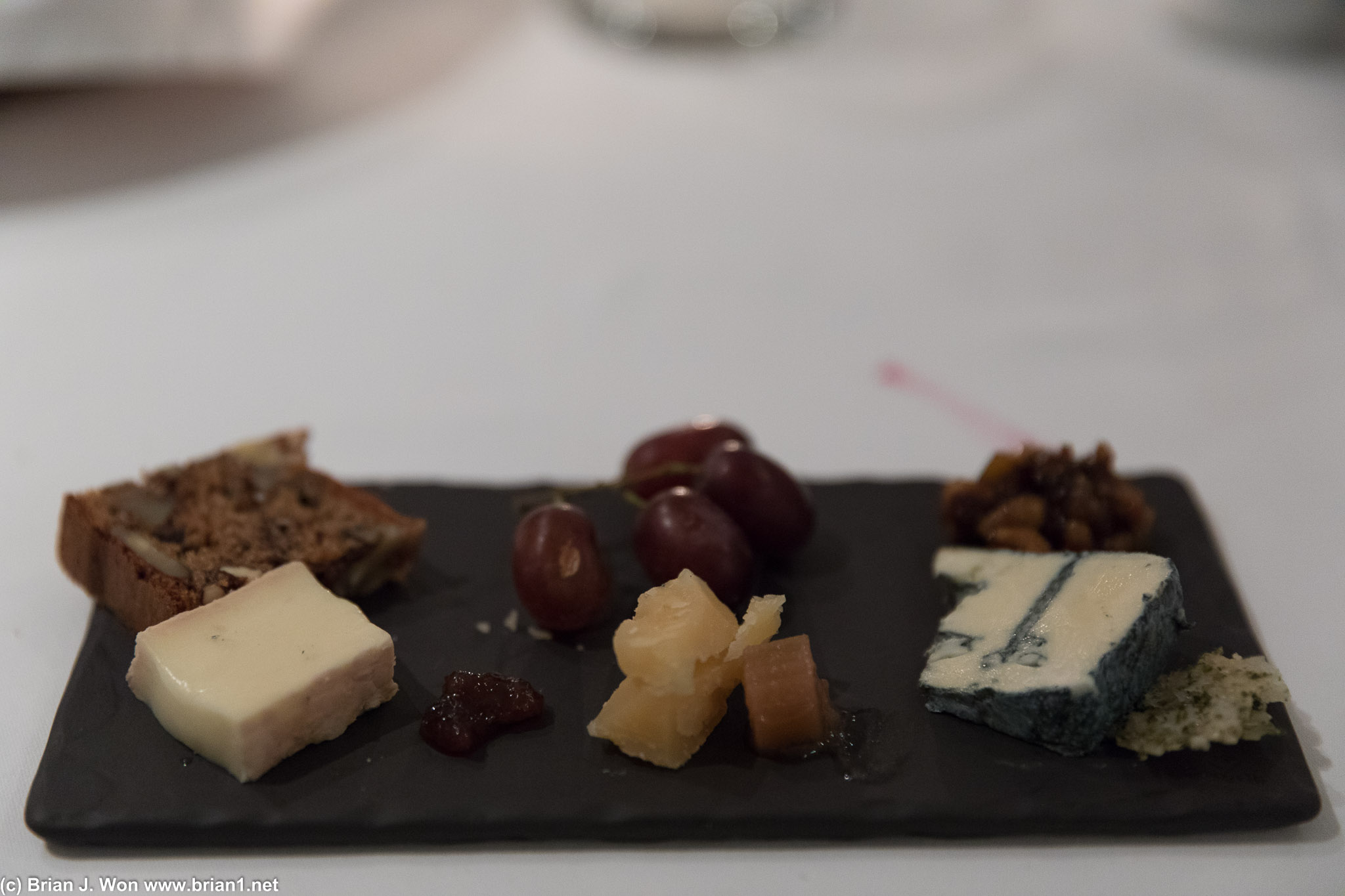 Cheese board, with grapes and fruit bread.
