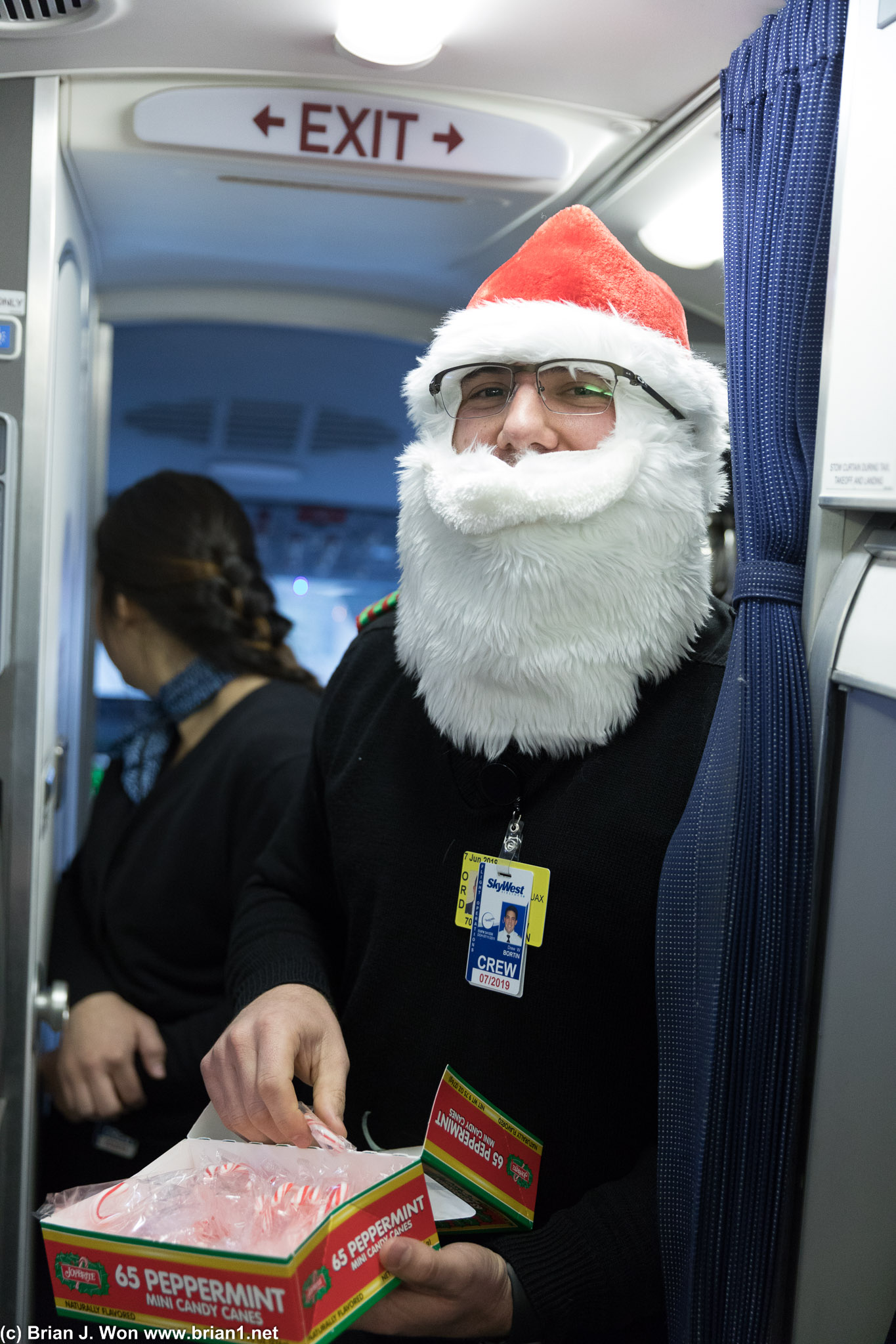 Flight attendants playing elves and handing out candy canes.