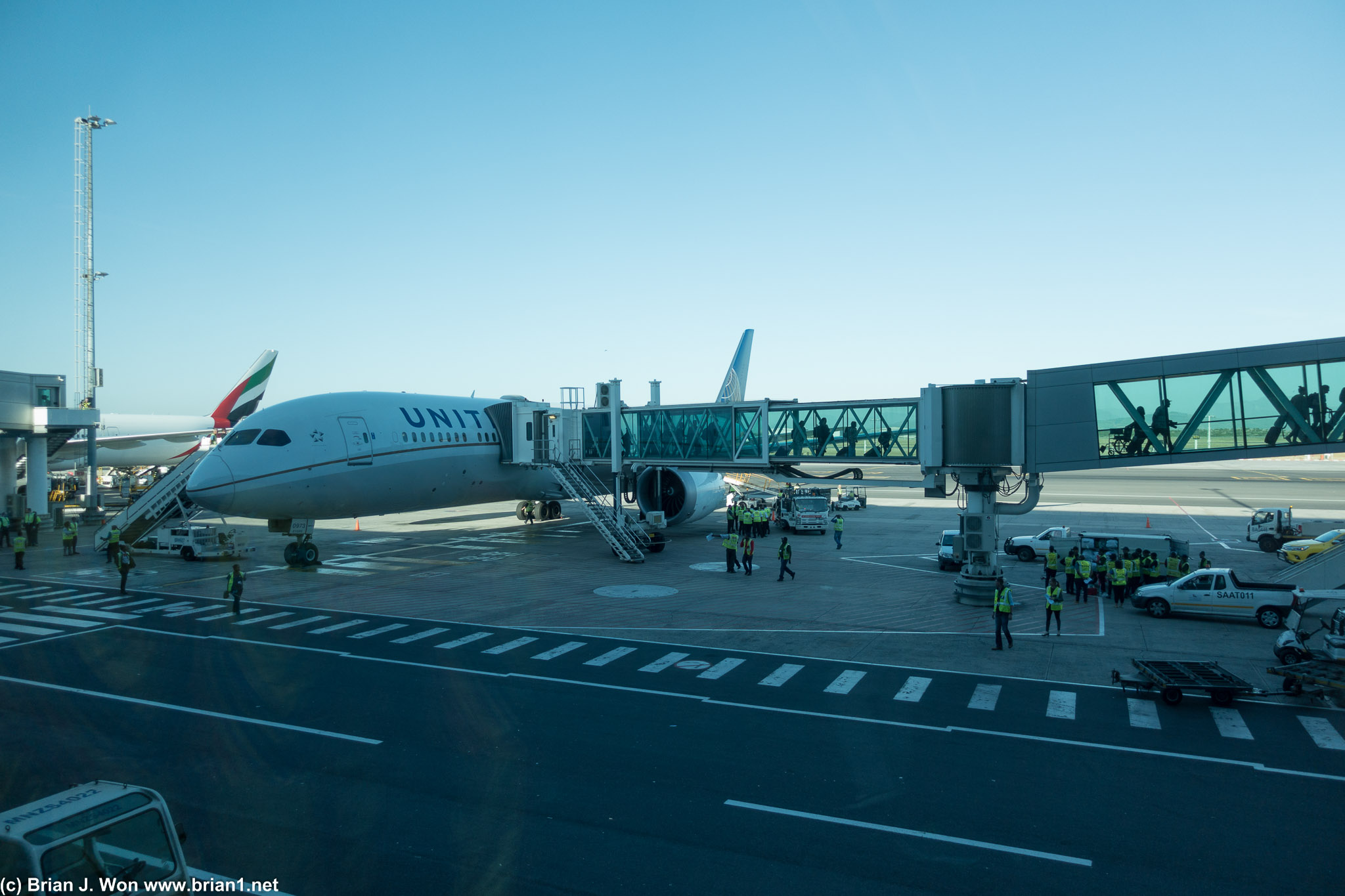 Long glass-enclosed jetbridges at CPT as viewed from the terminal.