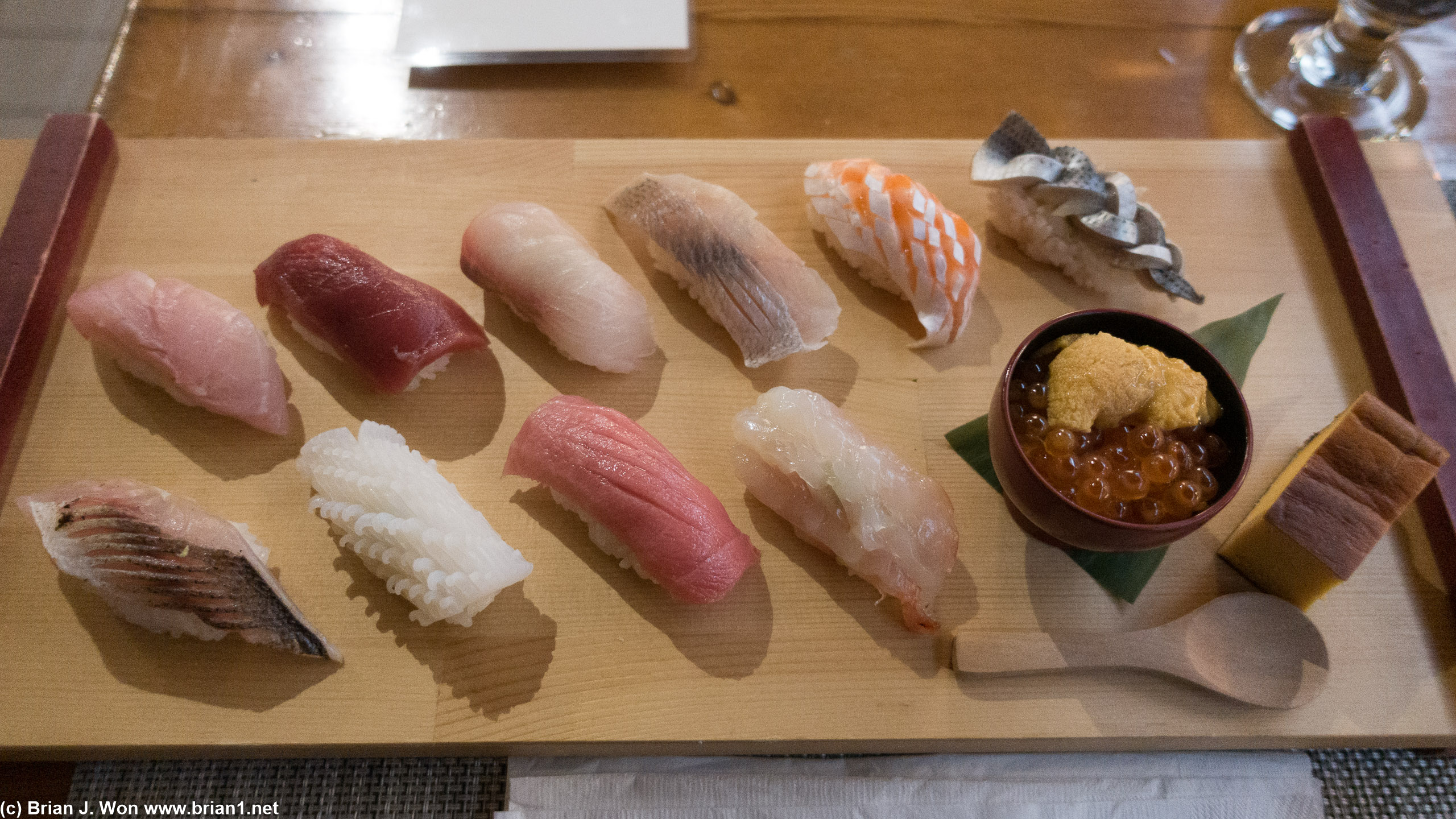 By row from top left: Striped jack, bluefin tuna, golden eye snapper, king mackerel, ocean trout, mackerel, barracuda, squid, chutoro, ama ebi, uni ikura, tamago.