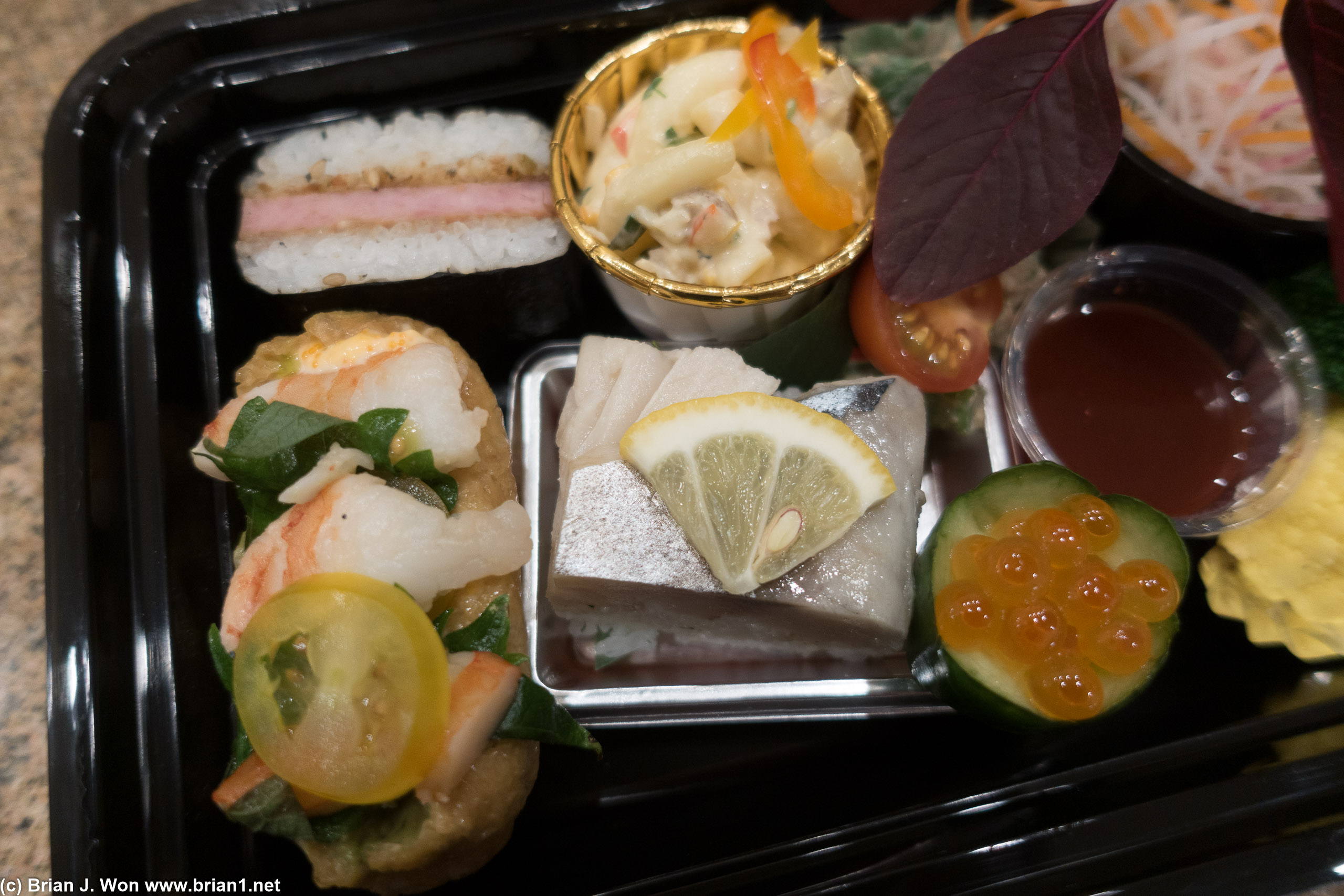 Saba oshizushi, gari, shiso next to shrimp and avocado inari, tuna macaroni salad, spam musubi...