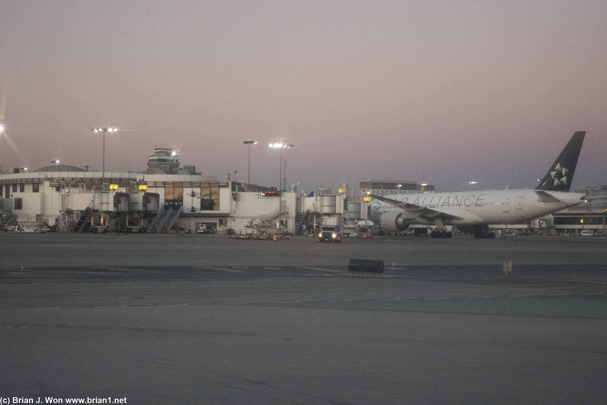 United 777-200ER parked at gate 76A.