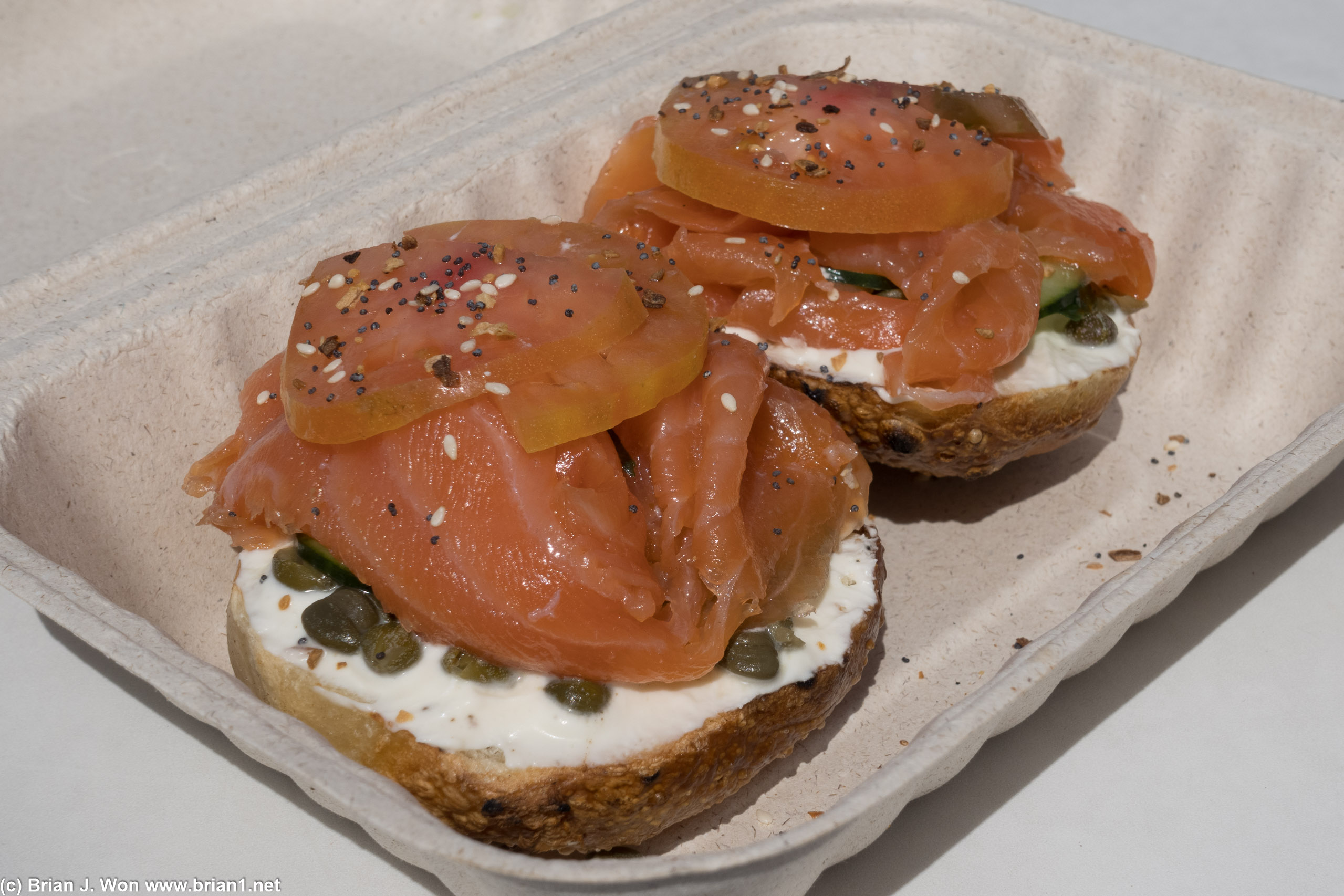 Plain bagel done up with lox, tomato, capers.