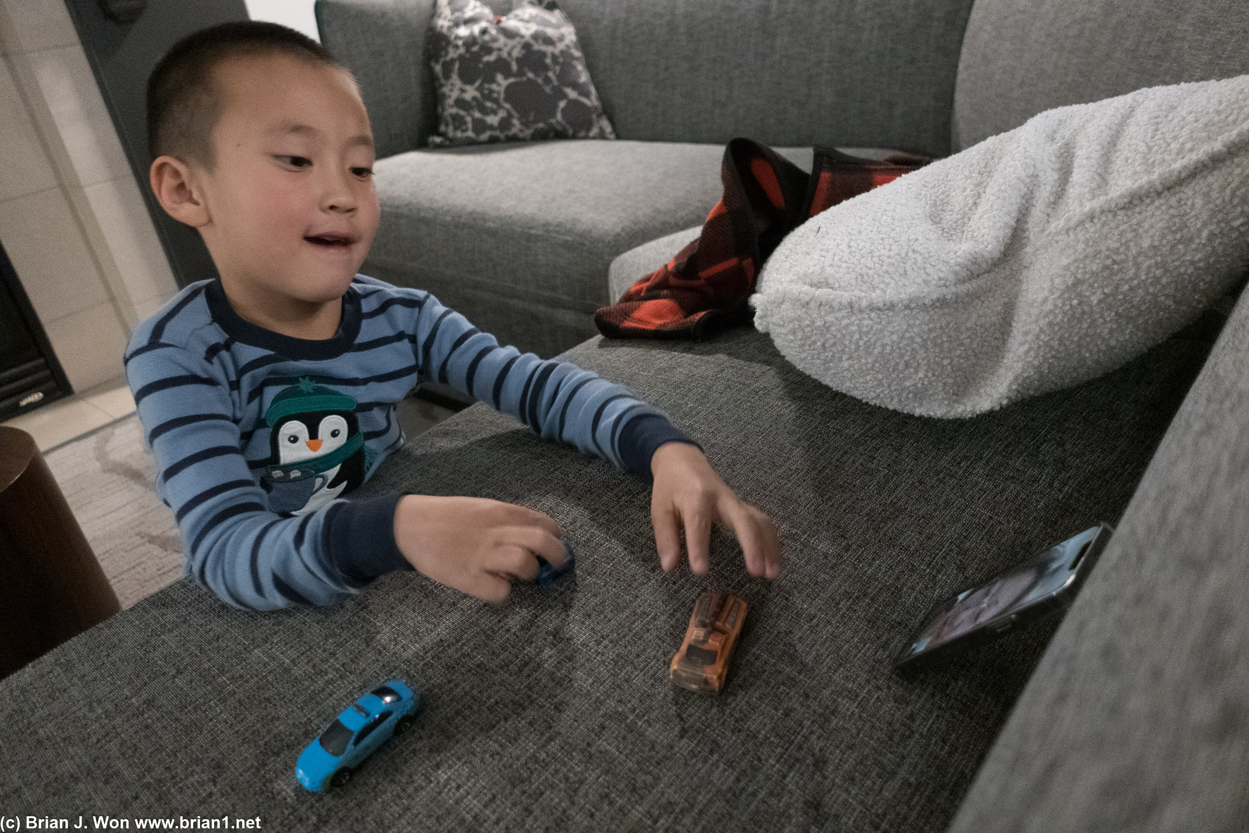 Playing with his cars while semi-ignoring his mom.