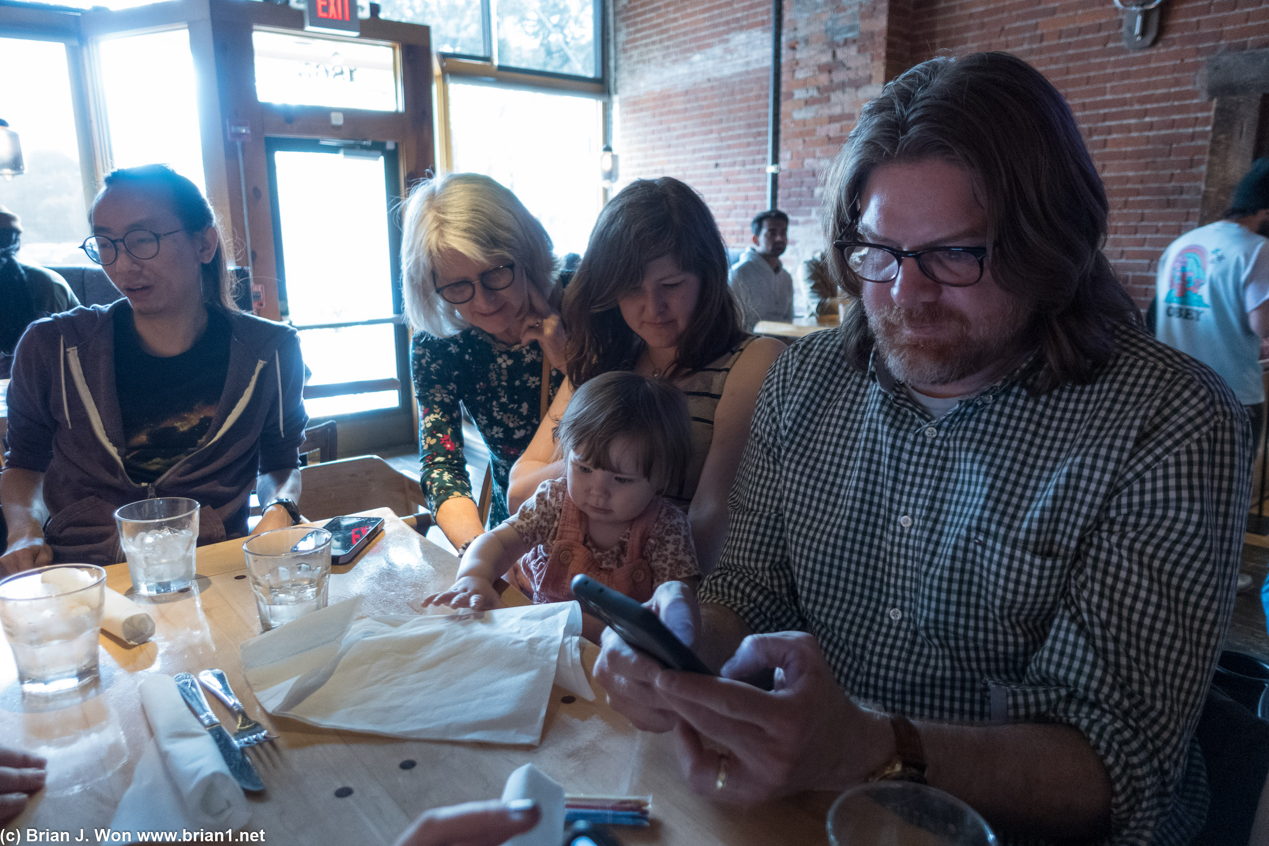 Adults reading menus, toddler playing with napkins.