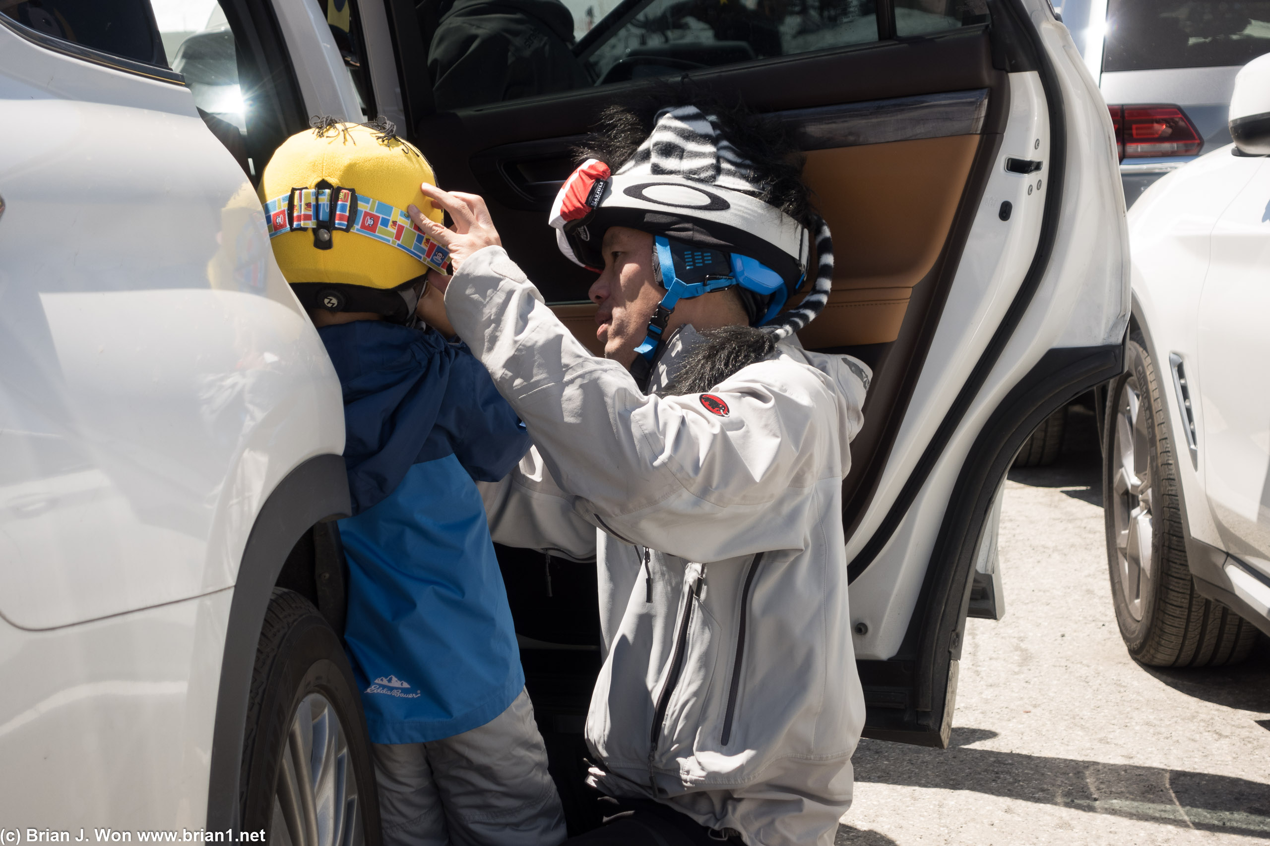 Devoted father preparing his son for the slopes.