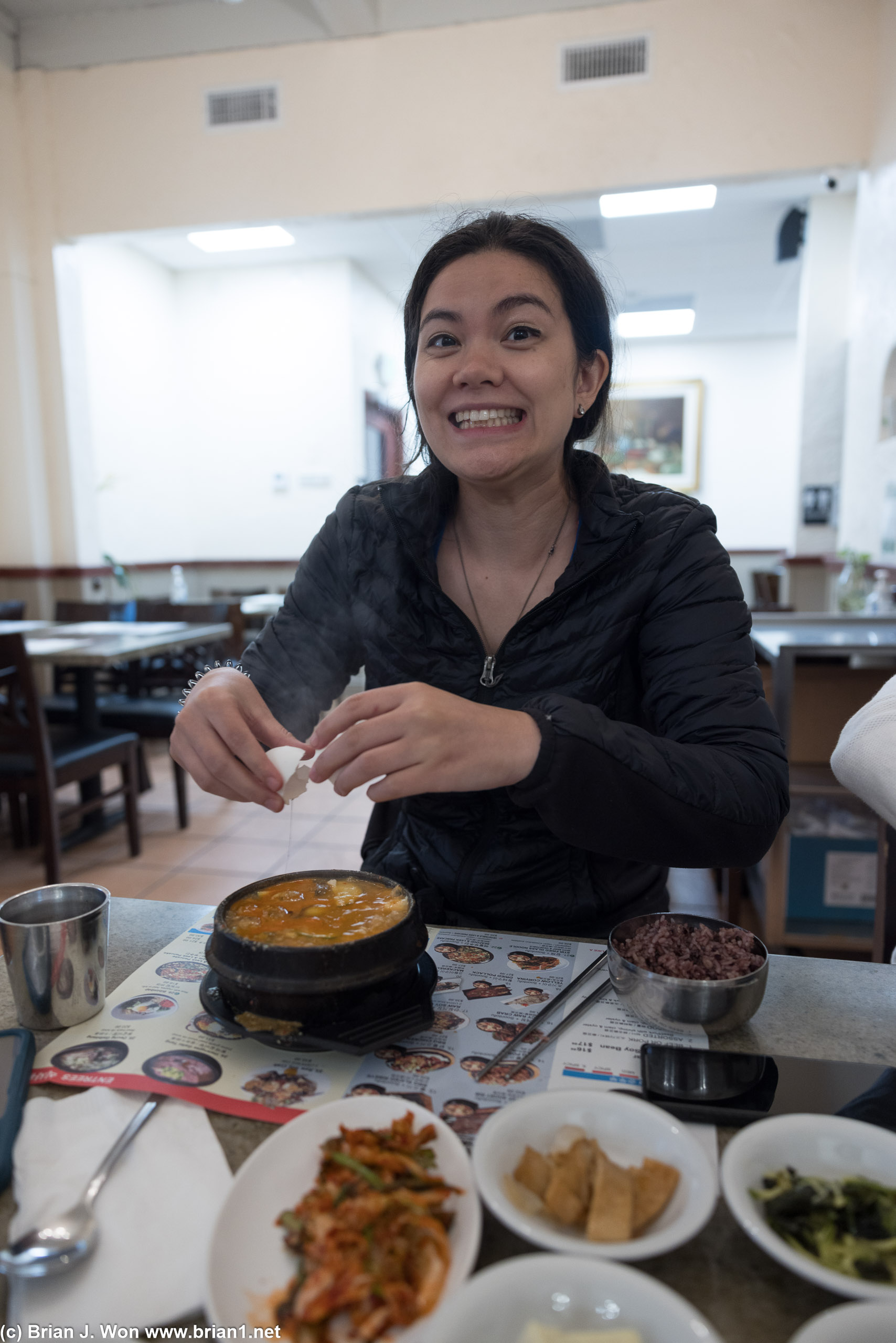 Cracking an egg into her tofu at Surawon Tofu House.