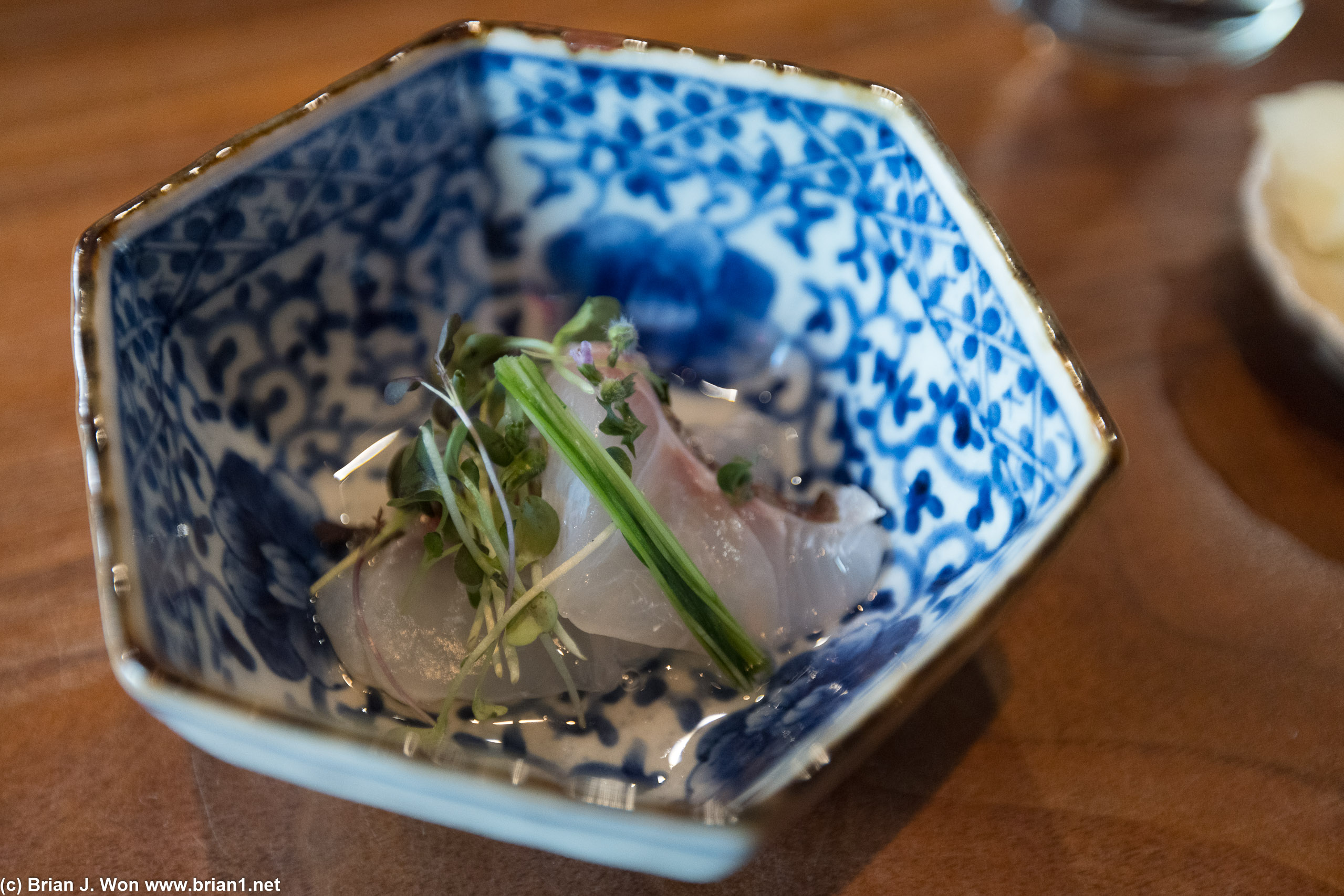 Madai (Japanese red snapper) sashimi with microgreens and clear soy sauce.
