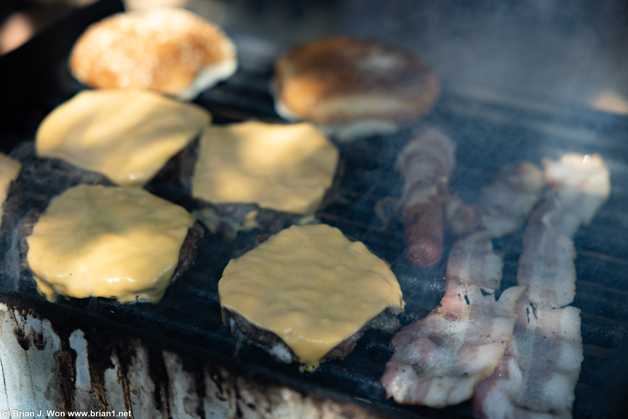 Cheeseburgers and bacon on the grill.