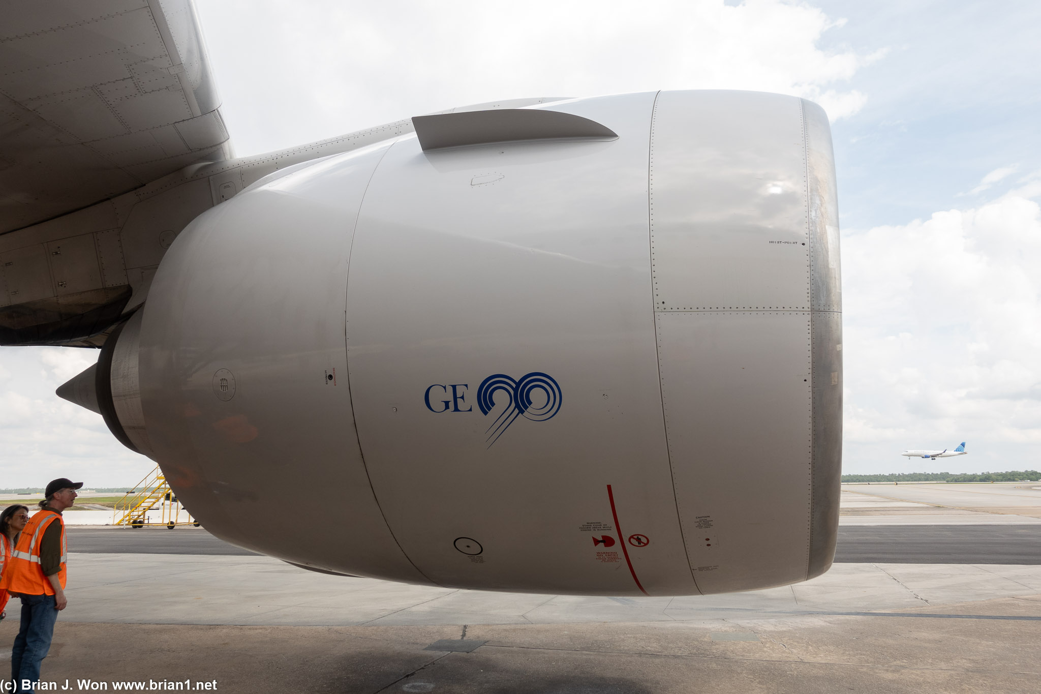 GE90 on a 777-200ER with a United Express Embraer 175 landing in the background.