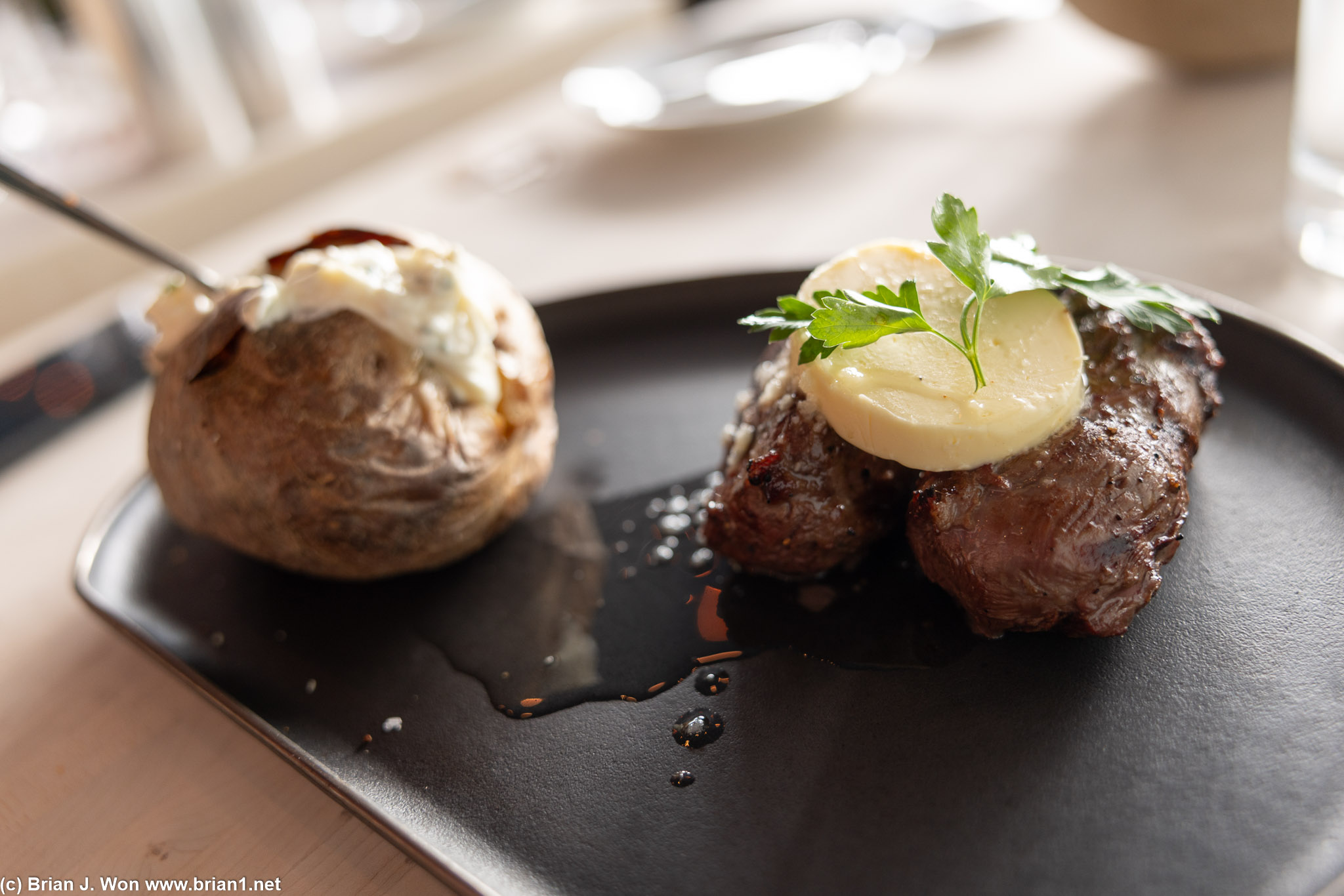 Greenlandic musk ox loin with a loaded baked potato.